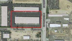 Aerial view of an industrial complex with a red outline around its outer perimeter along W Monsanto St and N Cloverdale Rd.