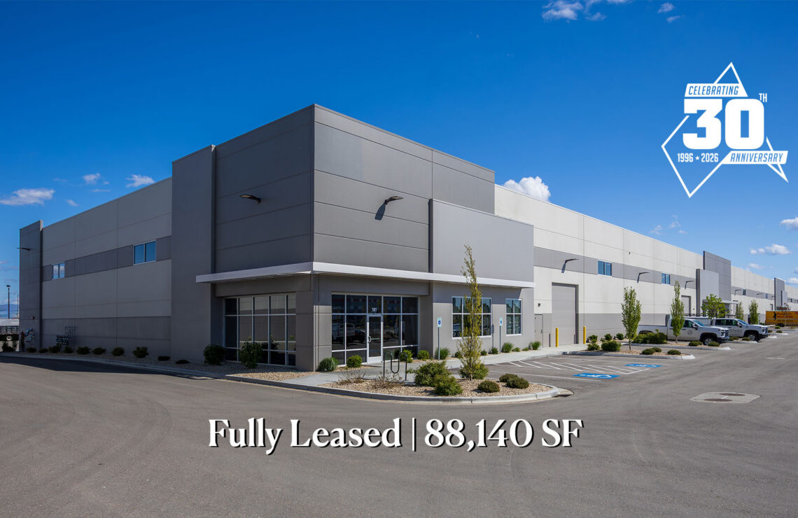 Modern industrial building with a glass entrance; text at bottom reads 'Fully Leased | 88,140 SF' against a clear blue sky.